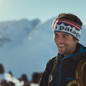 Lächelnder Skifahrer mit Stirnband in verschneiter Berglandschaft