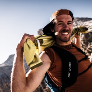 Mann mit gelbem Hund in bergiger Landschaft