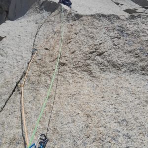 Kletterer beim Sportklettern an einer Granitfelswand mit Sicherungsseil